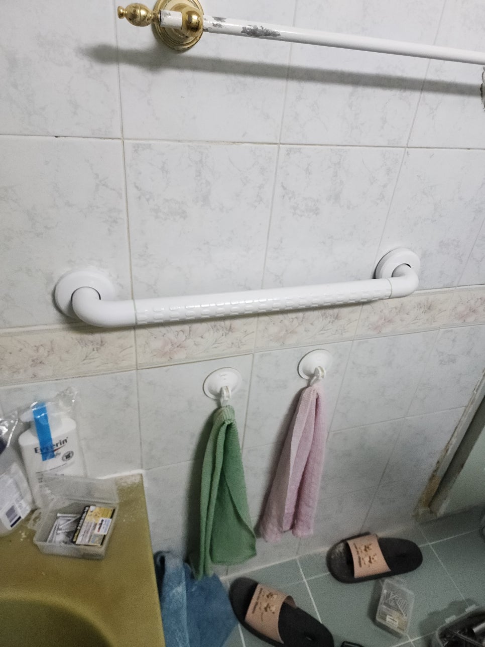 욕조 옆 벽면에 설치된 흰색 안전바