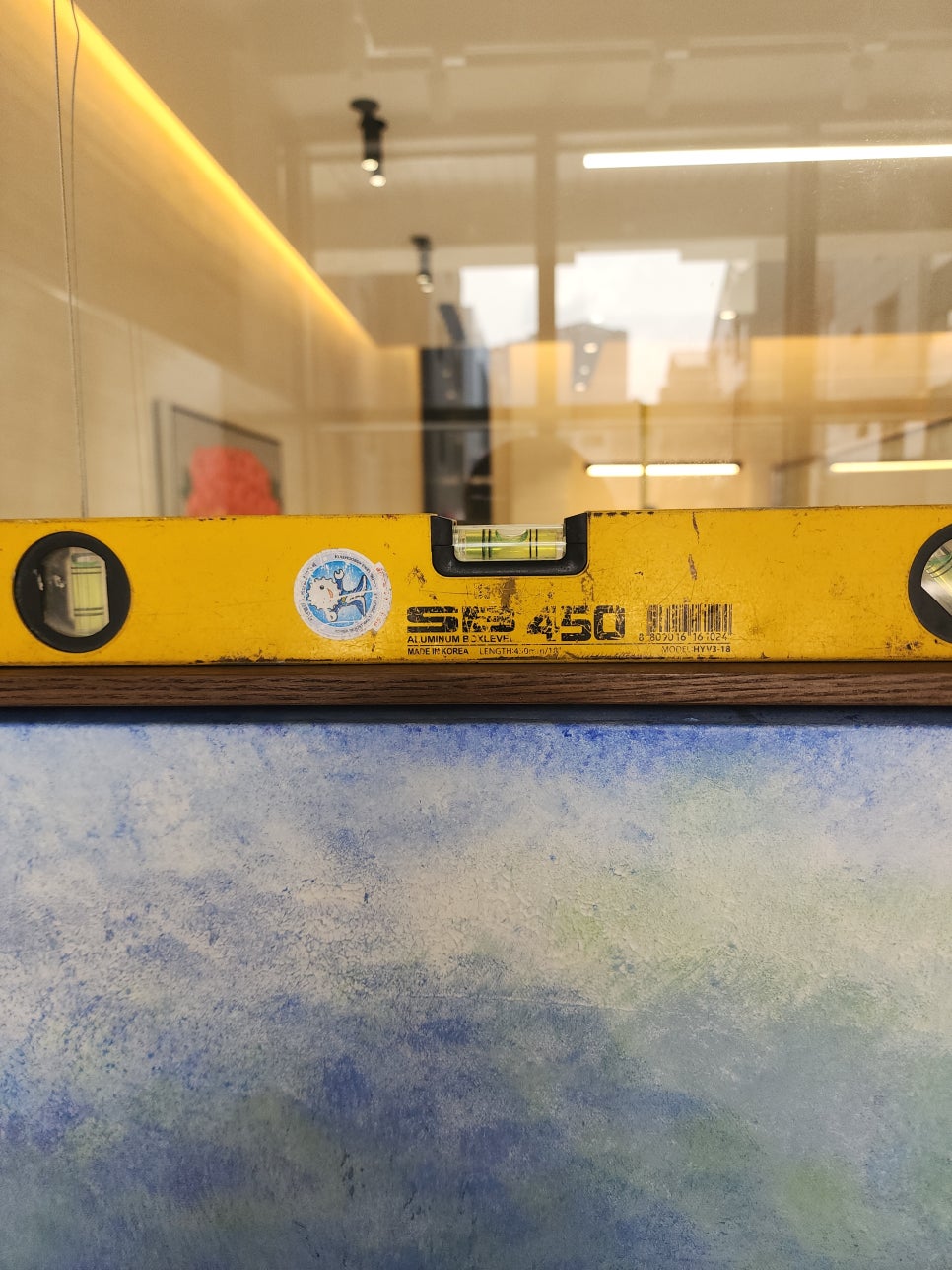 작품 상단에 수평계를 놓고 기울어짐을 확인하는 모습