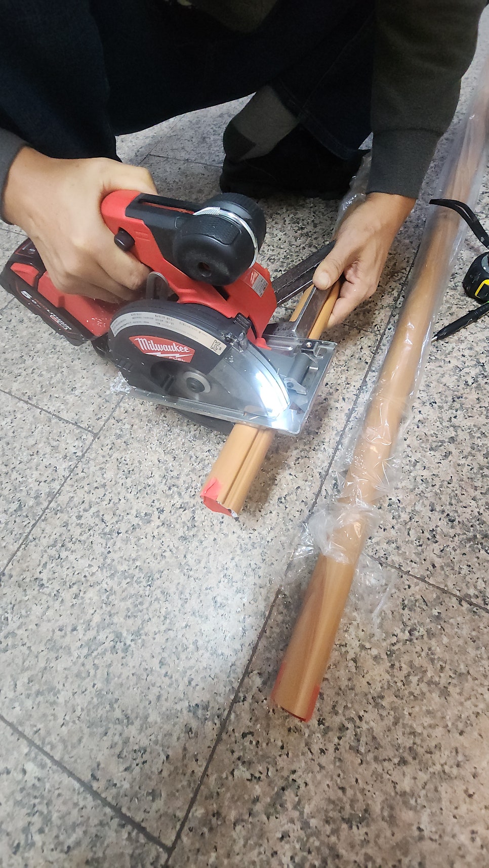 전동 공구로 핸드레일 부재를 현장에서 재단하는 모습