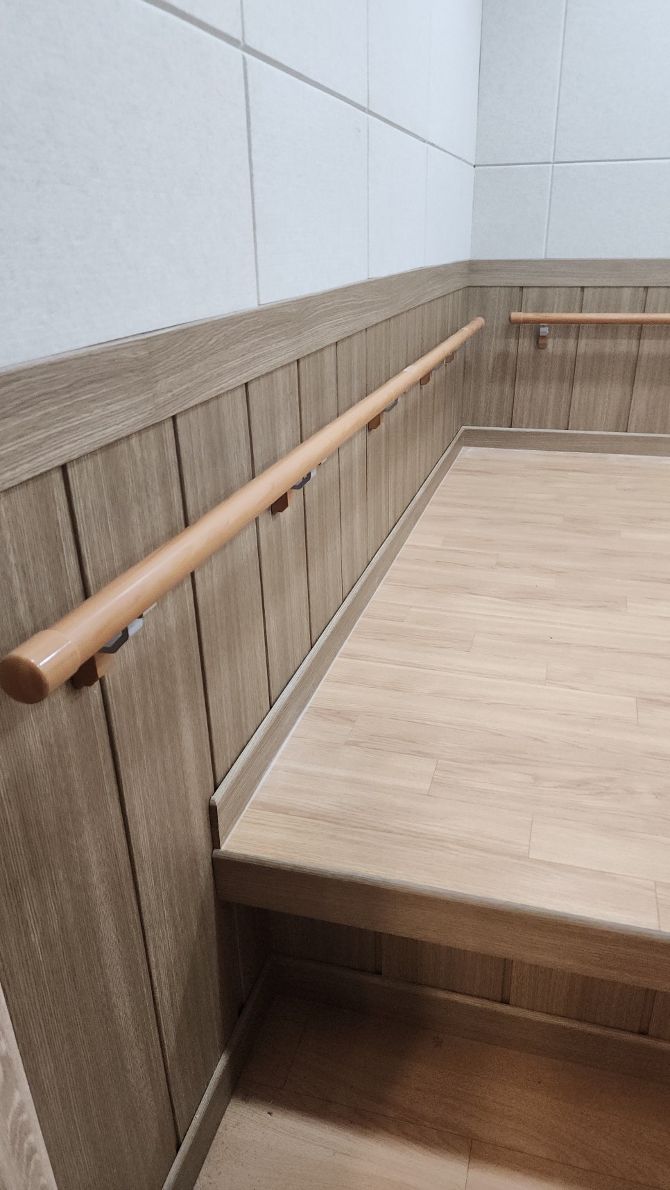 휴게실 벽면 브라켓에 체결된 긴 핸드레일 설치 모습