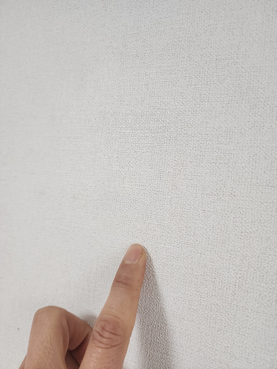 복구한 벽지 부위를 손가락으로 가리키며 확인하는 모습