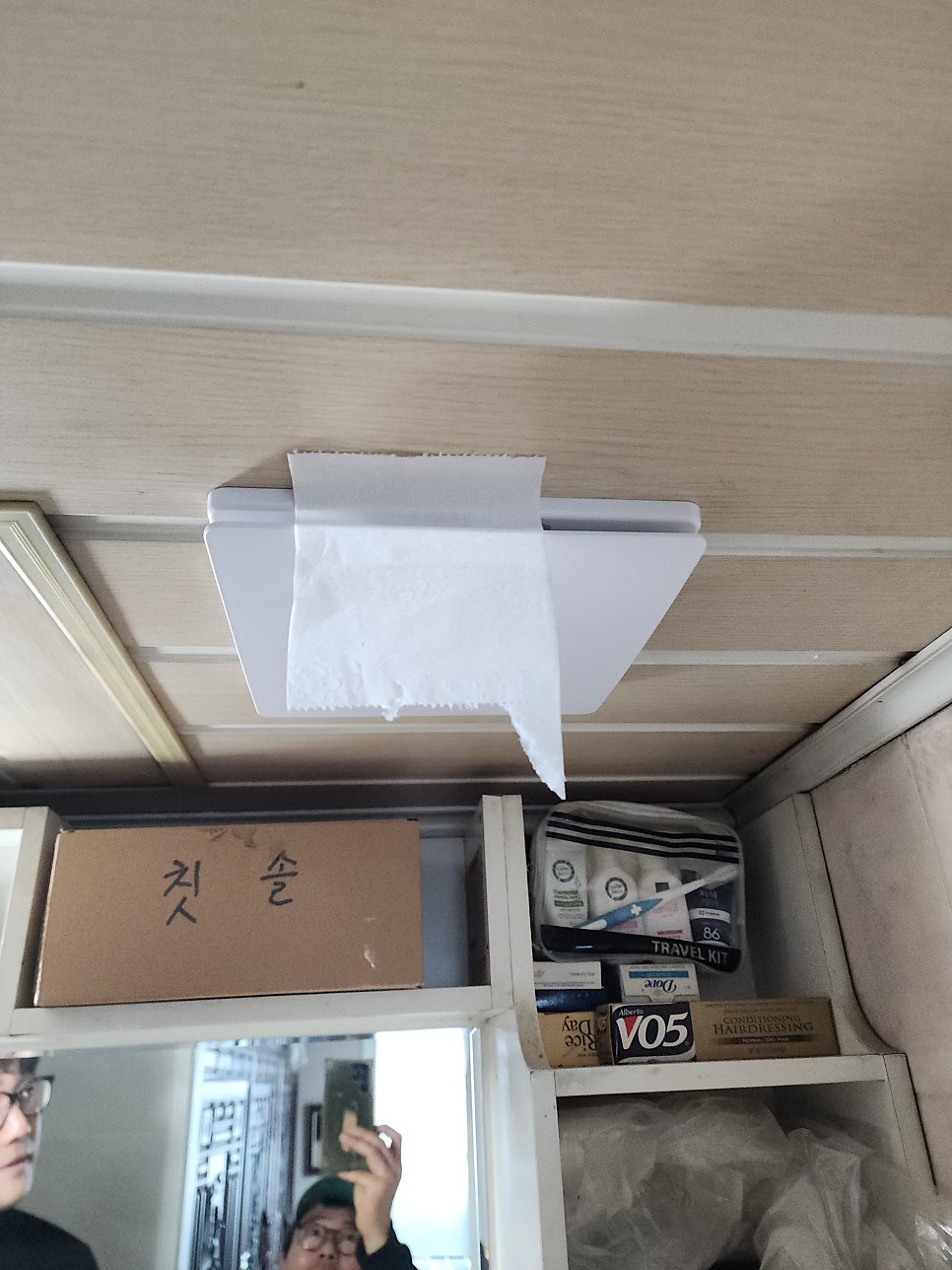 교체한 욕실 환풍기 커버에 붙인 휴지로 흡입력을 확인하는 모습