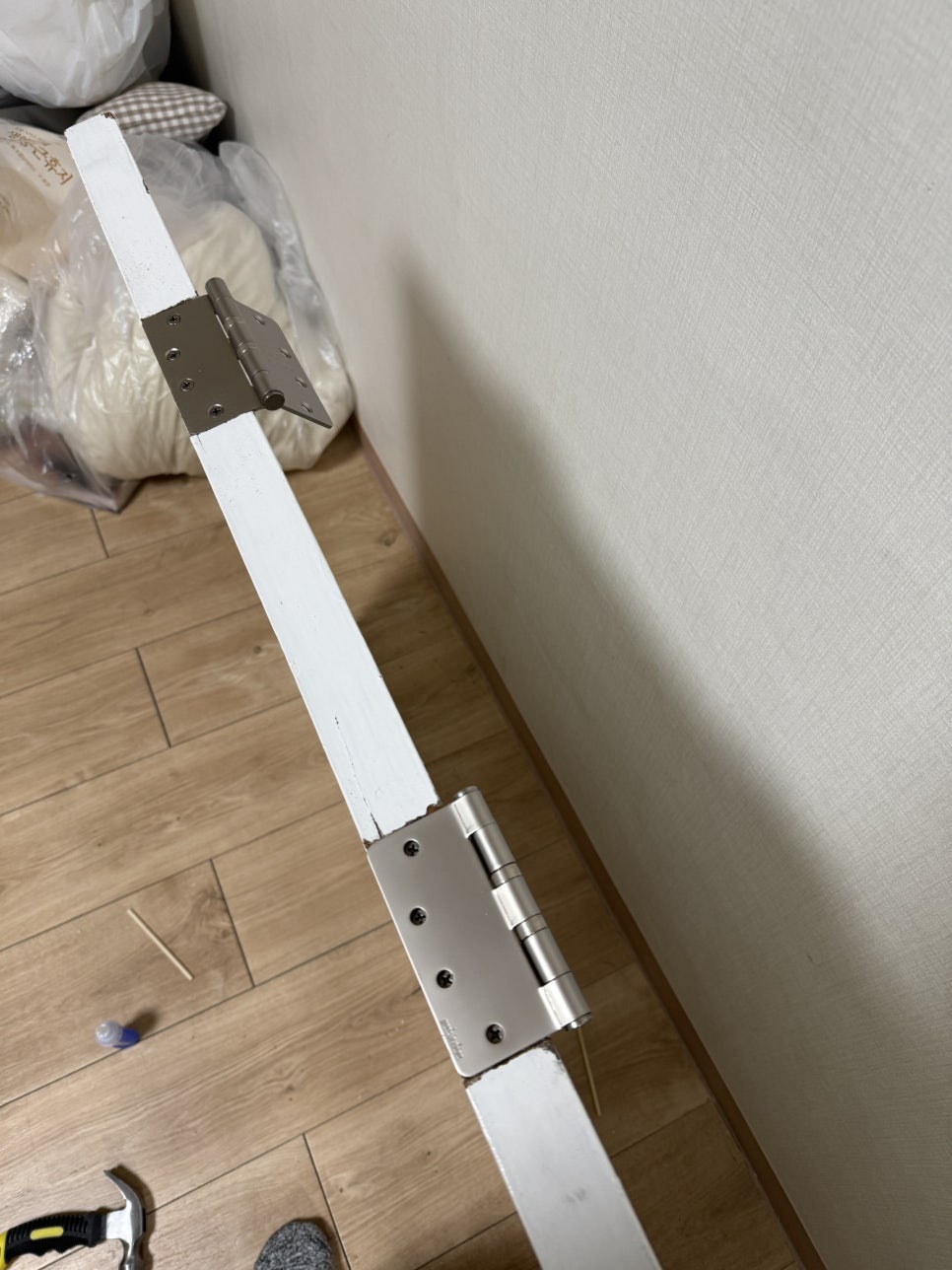 문짝 가장자리에 새 나비경첩 두 개를 설치한 모습