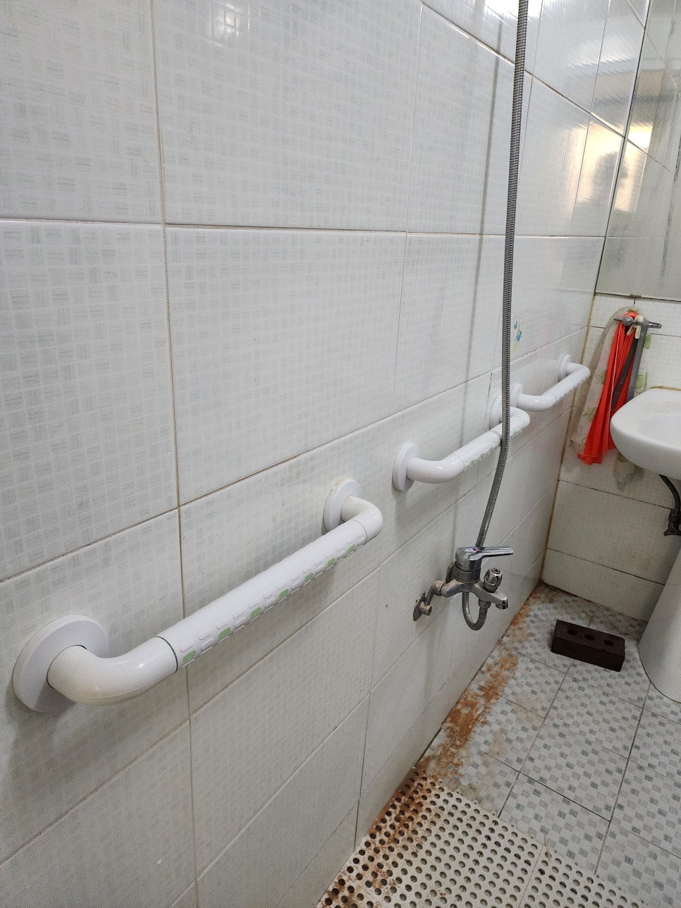 욕실 벽면에 가로와 세로로 설치를 마친 안전손잡이