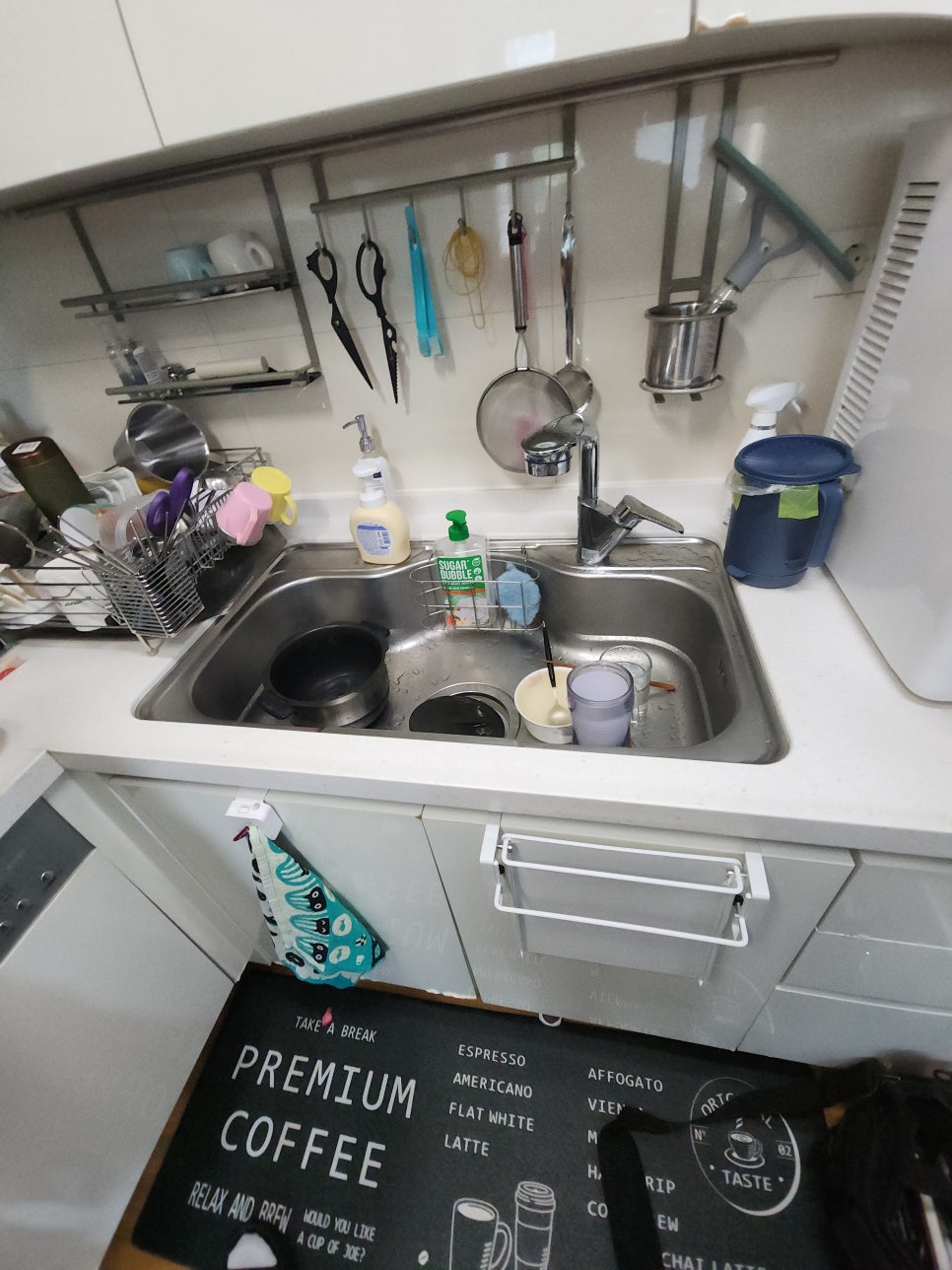 기존 싱크볼과 수전이 설치된 주방 상판과 열린 하부장