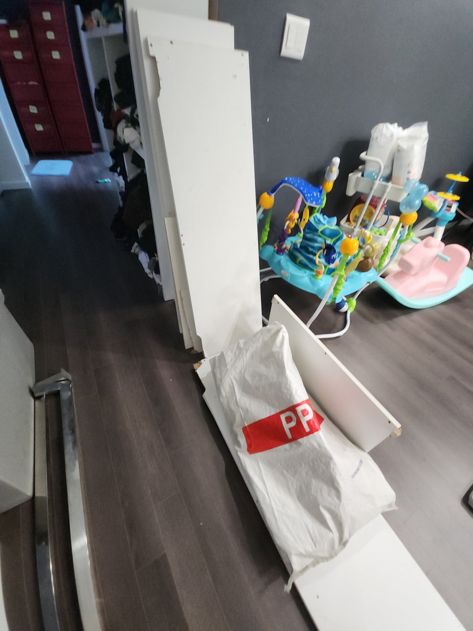 실내 바닥에 모아 둔 흰색 상부장 판재와 폐기물 자루