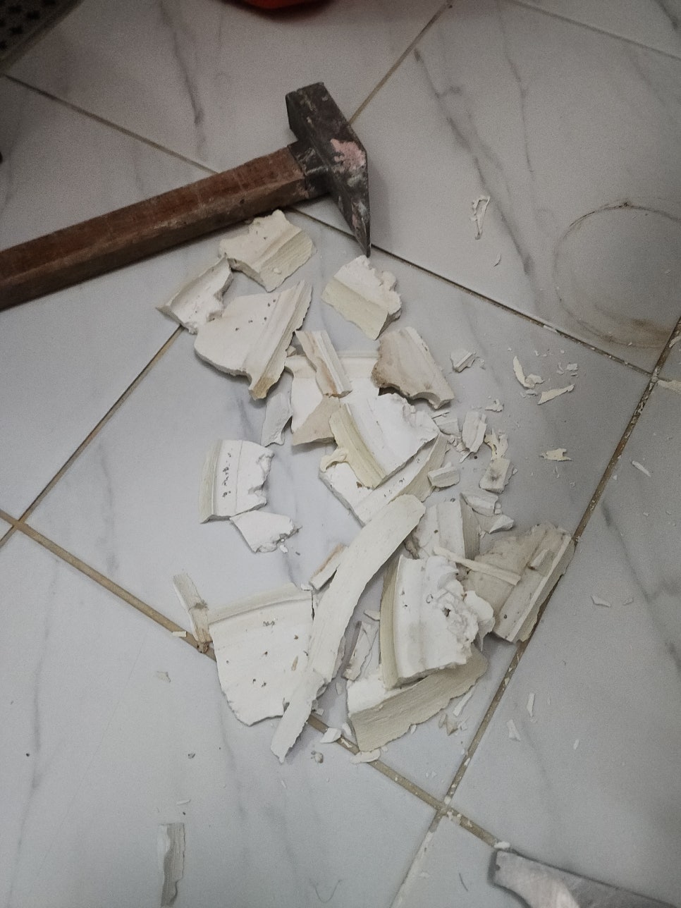 철거한 백시멘트 조각과 바닥에 놓인 망치