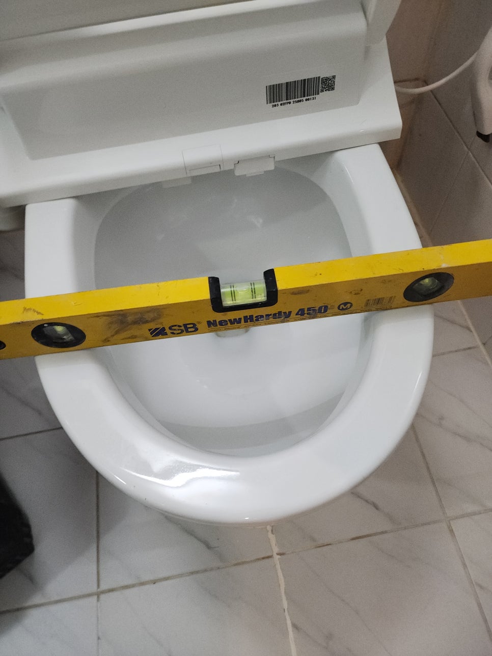 변기 위에 수평대를 놓고 수평을 확인하는 모습