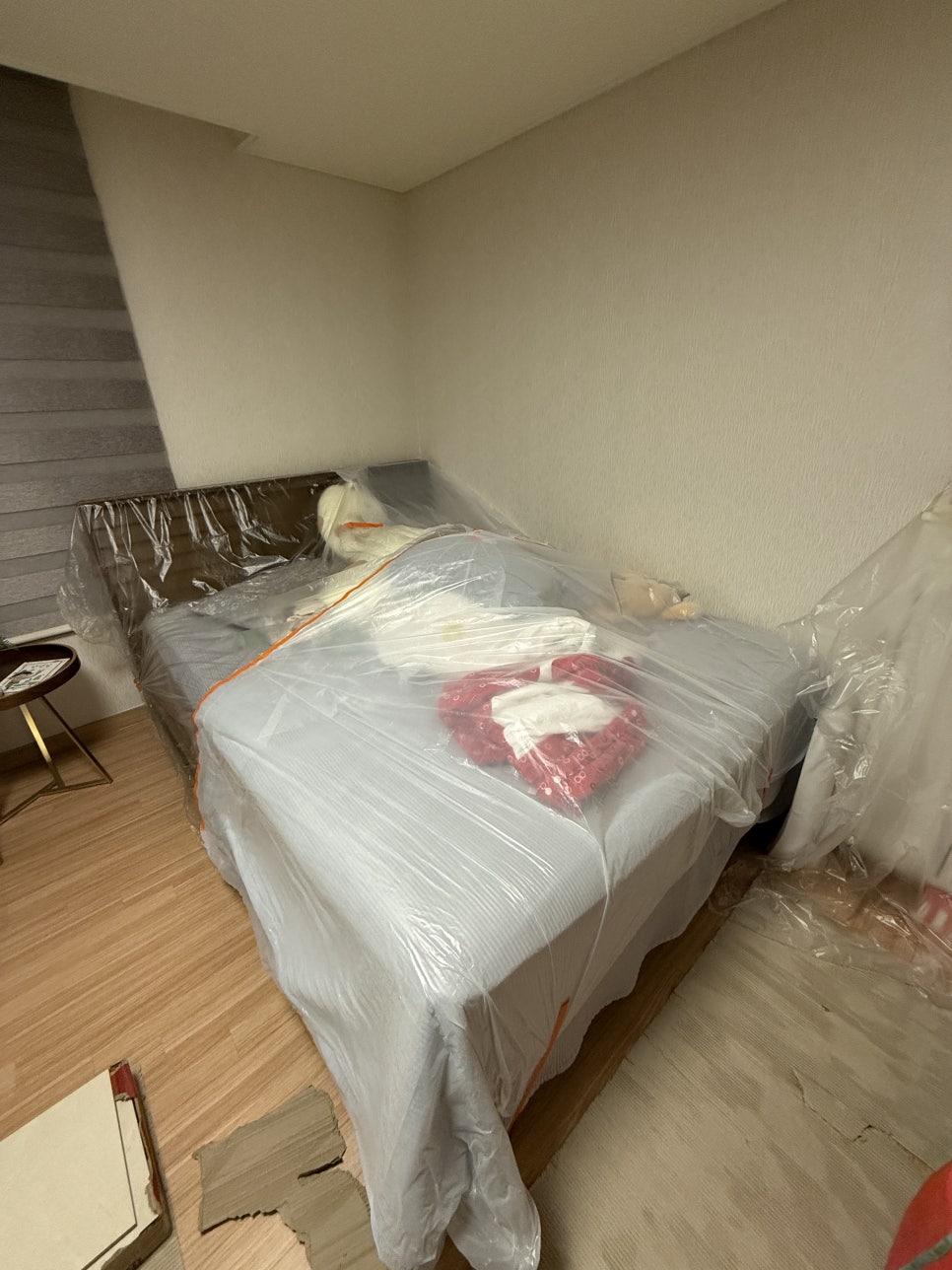 비닐로 덮어 보양한 침대와 주변 가구