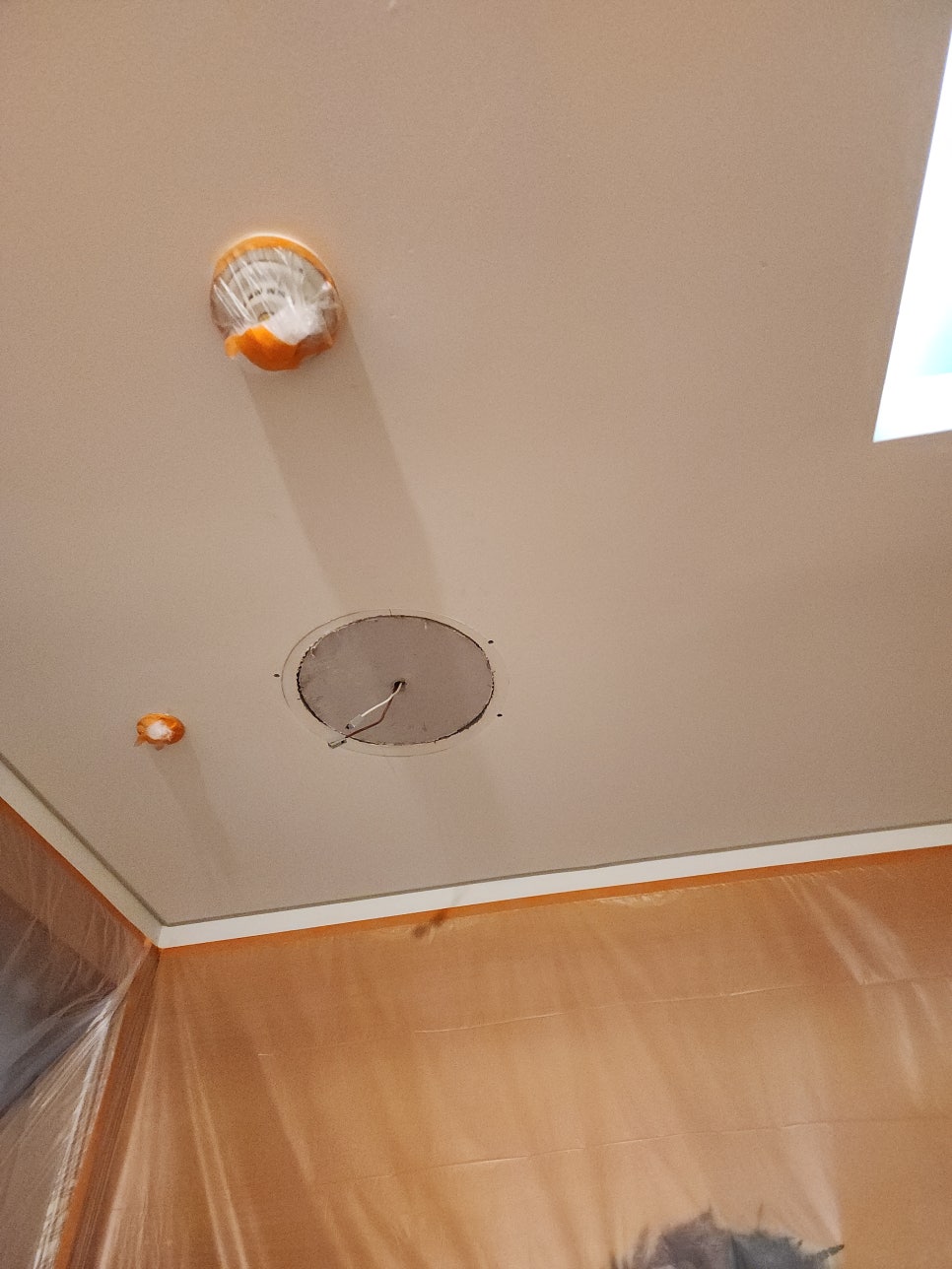 전선을 빼낸 새 석고보드가 천장 조명 자리에 고정된 모습