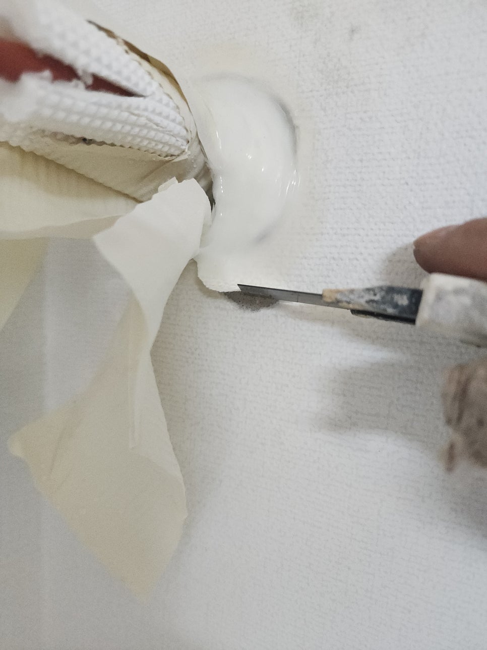 에어컨 배관 주변의 실리콘 잔여물을 칼로 정리하는 모습