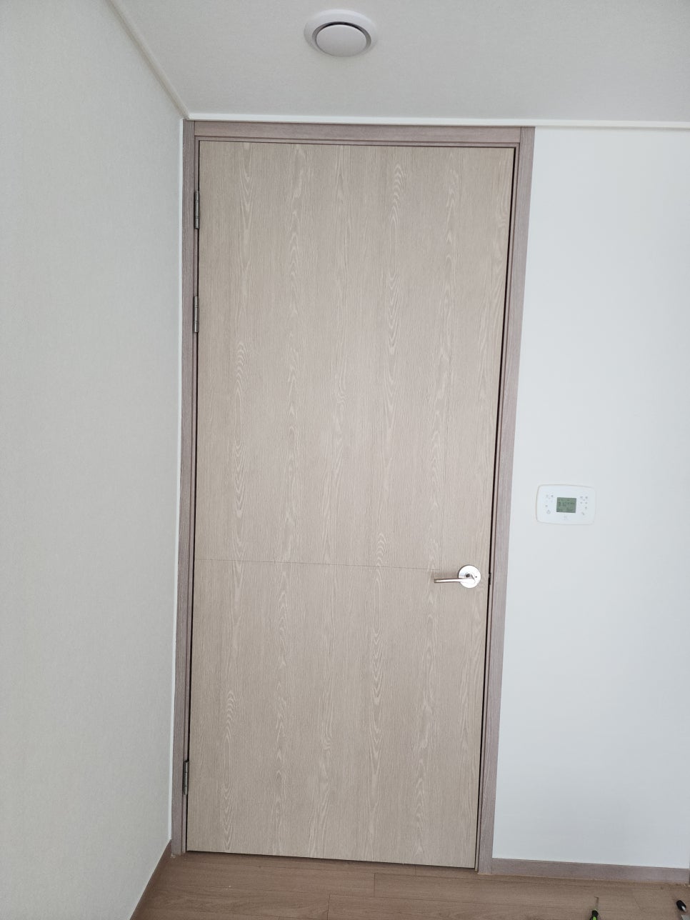 새 필름 시공 후 문고리를 다시 설치한 방문 전면