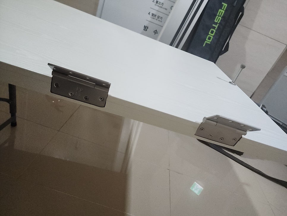 분리한 욕실문에 새 경첩을 설치한 모습