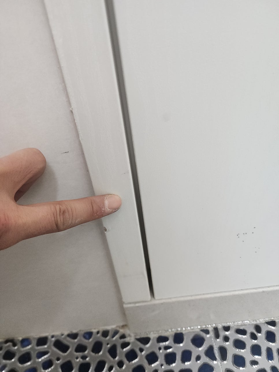 문지방과 욕실문 하단 사이의 간격을 가리키는 손