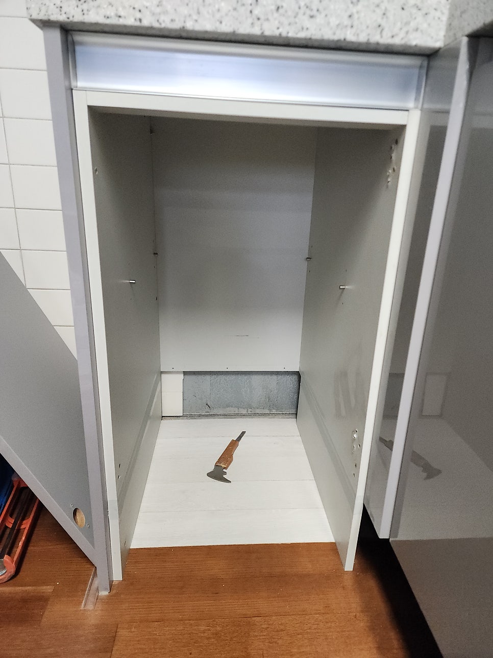 하부장 내부 바닥에 흰색 장판을 깔고 도구를 놓은 모습