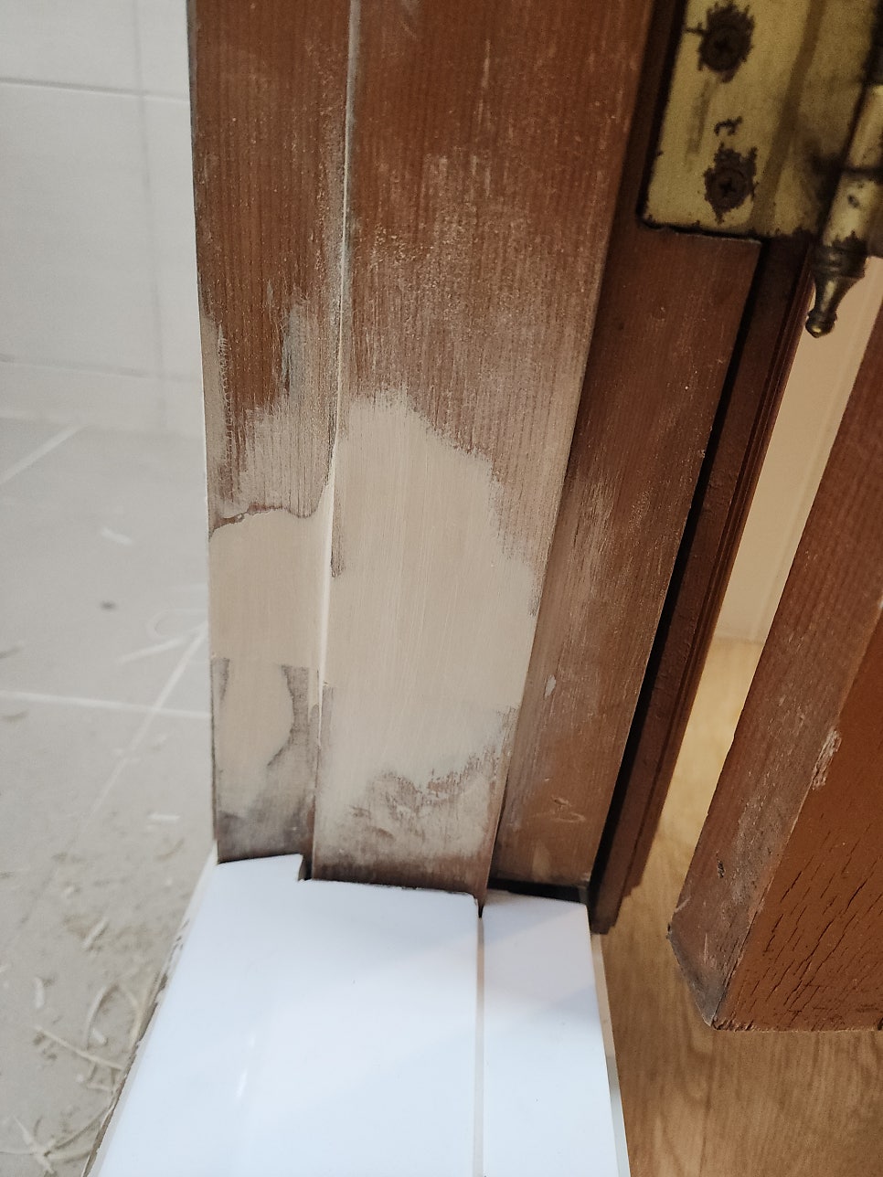 문틀 하단과 옆면에 맞춰 설치한 흰색 문지방 마감재