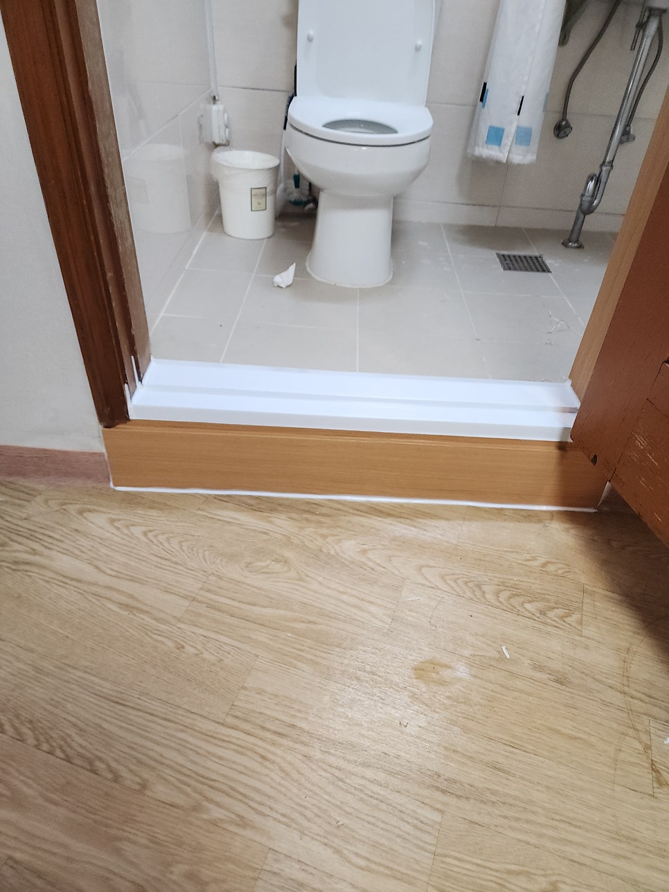 욕실 출입구에 설치를 마친 흰색 인조대리석 문지방