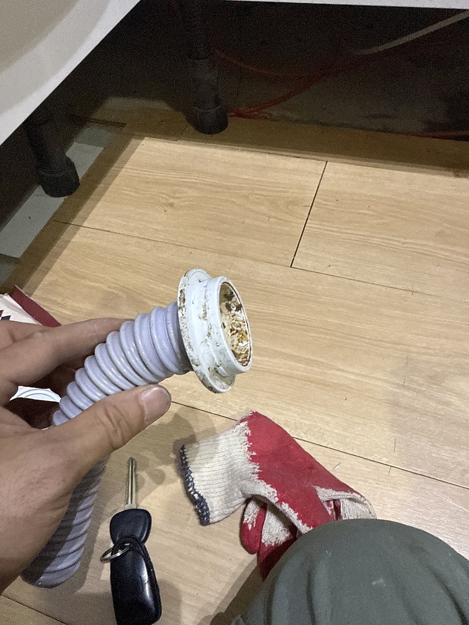 분리한 싱크대 배수호스 끝부분과 배수구 연결 부속을 확인하는 모습