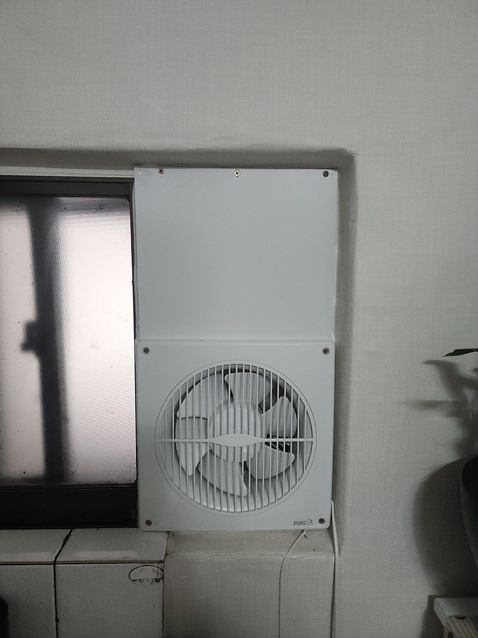 흰색 막음판에 고정한 창문형 환풍기 본체