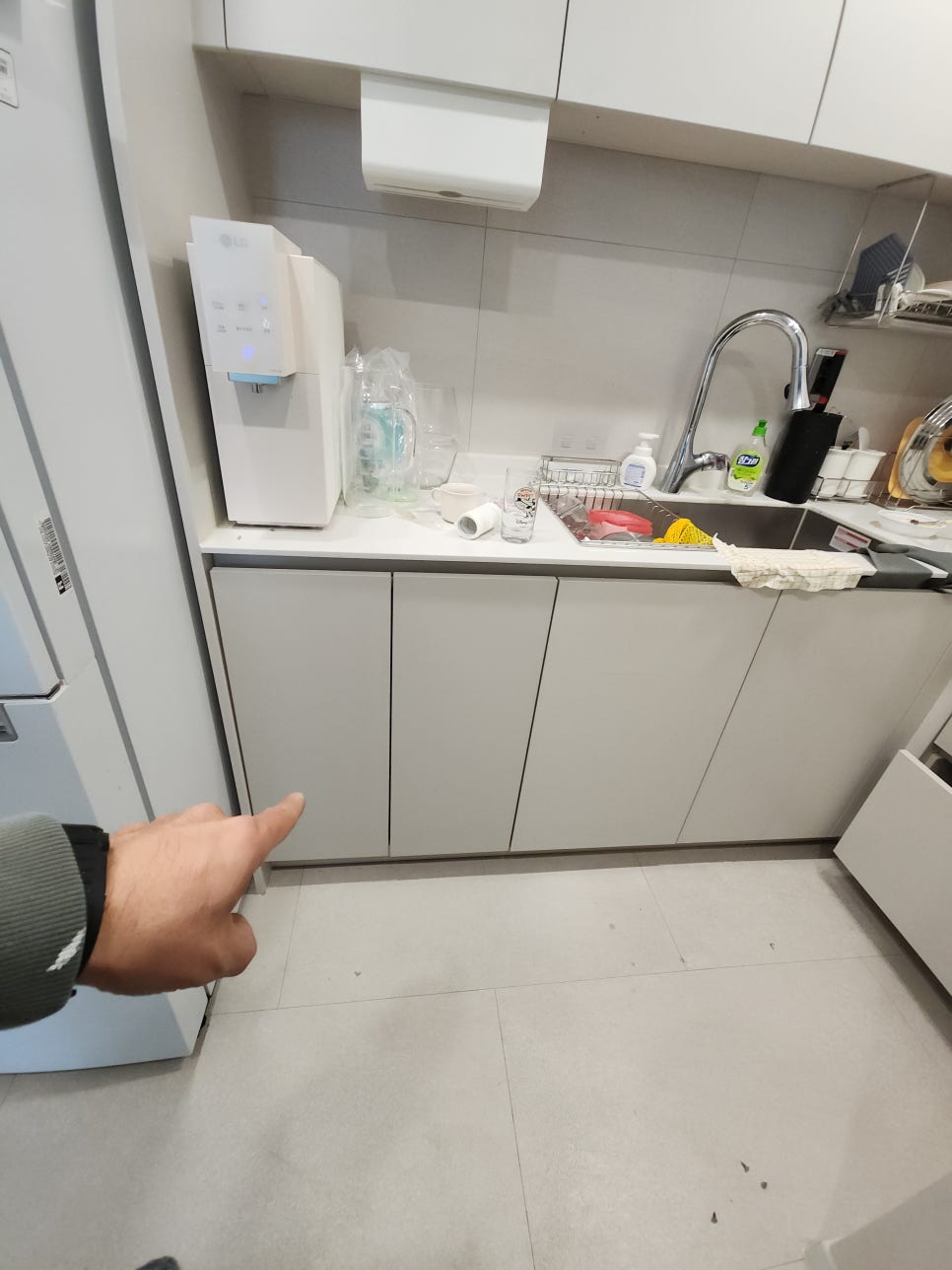 싱크대 하부장 문짝을 닫아 주변 수납장과 라인을 확인하는 모습