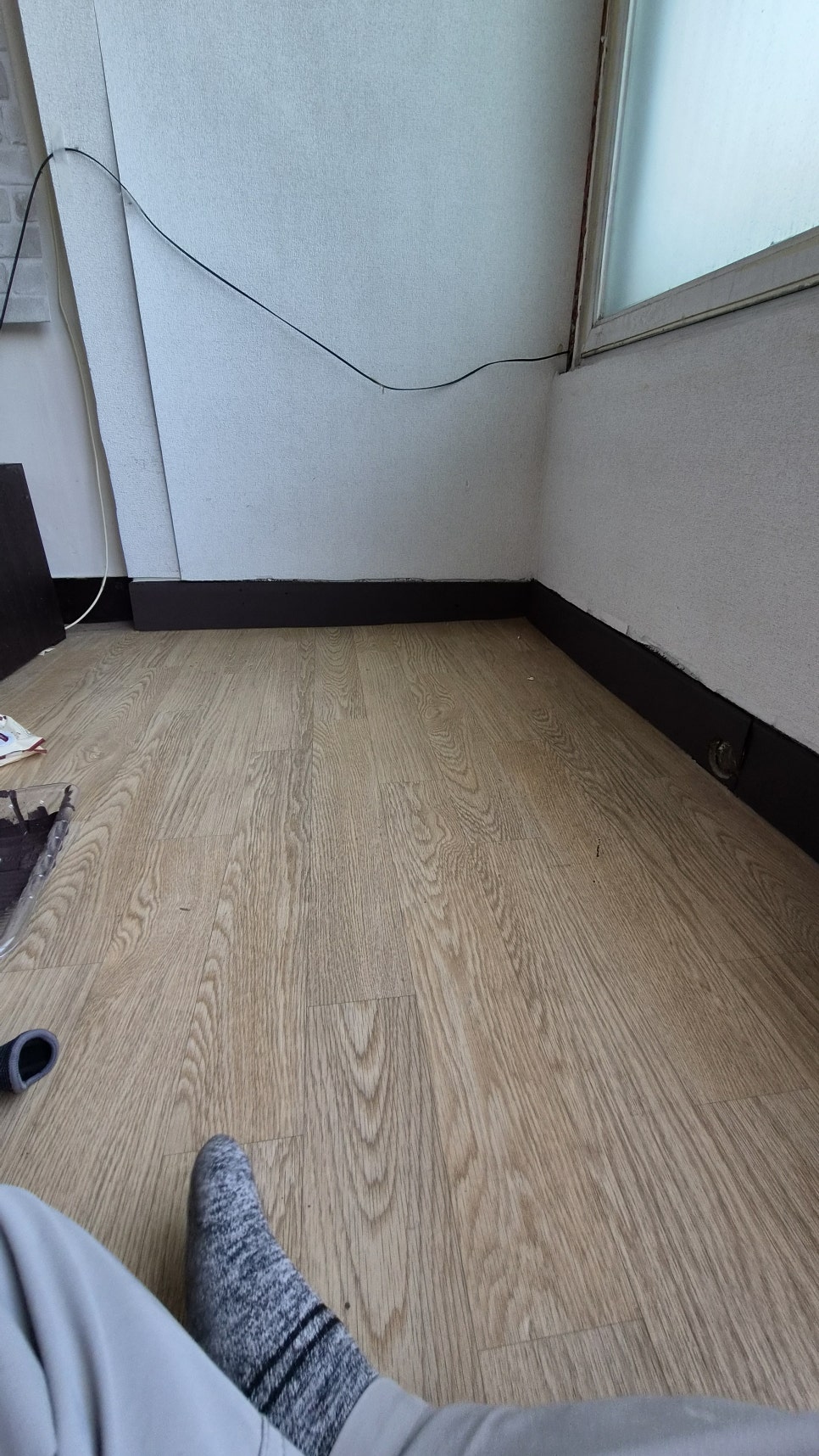 보양 비닐 주변으로 어두운 색 페인트를 칠한 걸레받이 상태